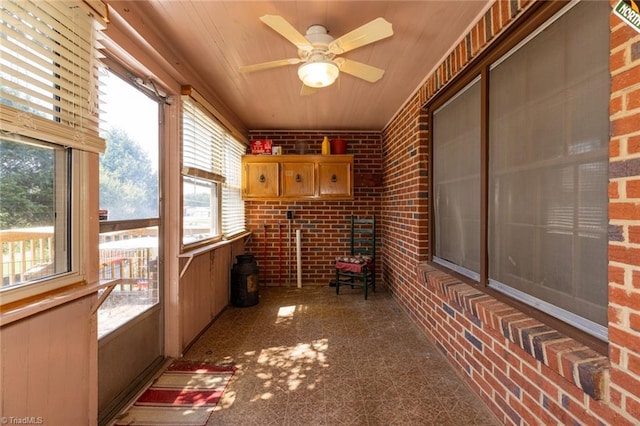 sunroom with ceiling fan, a healthy amount of sunlight, and wooden ceiling