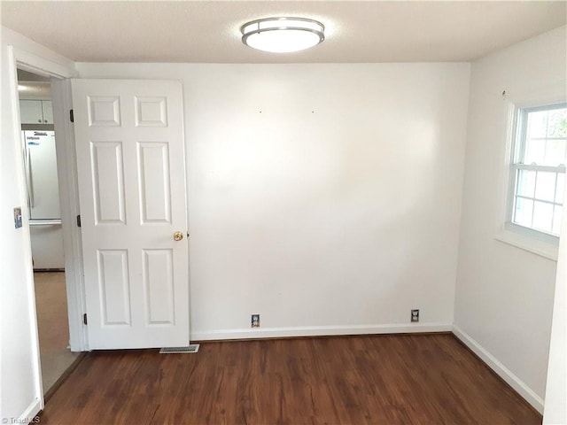 unfurnished room featuring dark wood-type flooring