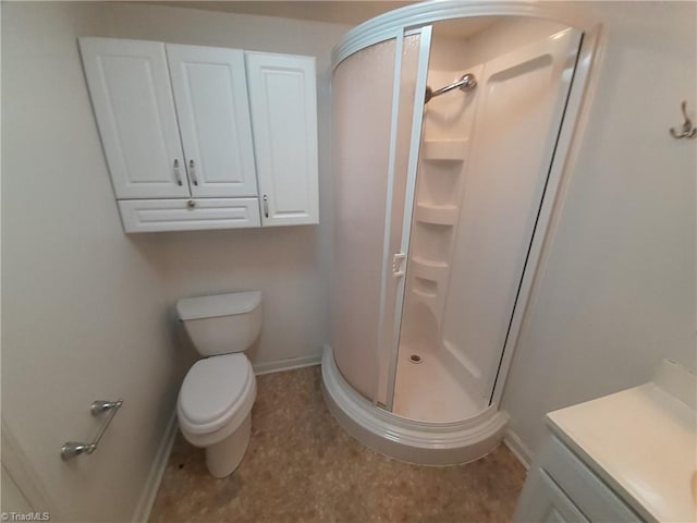 bathroom featuring vanity, toilet, and walk in shower