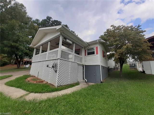 view of home's exterior with covered porch, ceiling fan, and a lawn