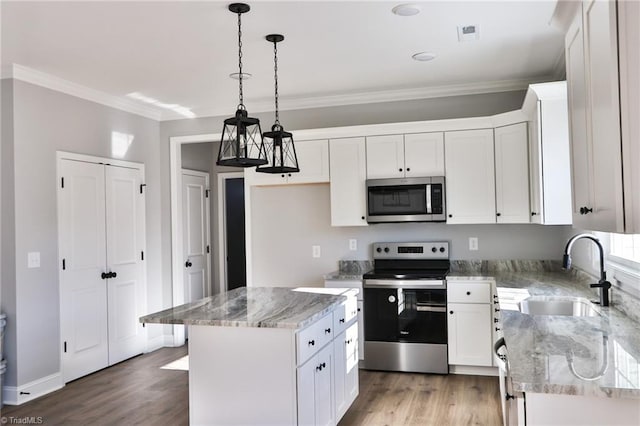 kitchen featuring white cabinets, stainless steel appliances, a kitchen island, and sink