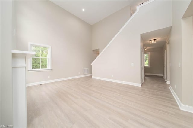 2578 Whipporwill Ct, Rural Hall, NC 27045 - unfurnished living room with light wood-type flooring, baseboards, and a towering ceiling