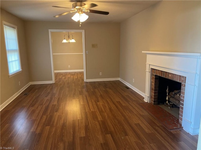 unfurnished living room featuring dark wood-type flooring, a brick fireplace, and ceiling fan