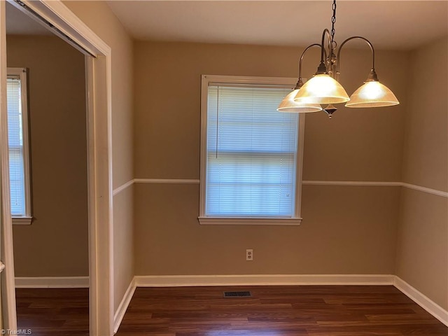 unfurnished dining area featuring dark hardwood / wood-style flooring