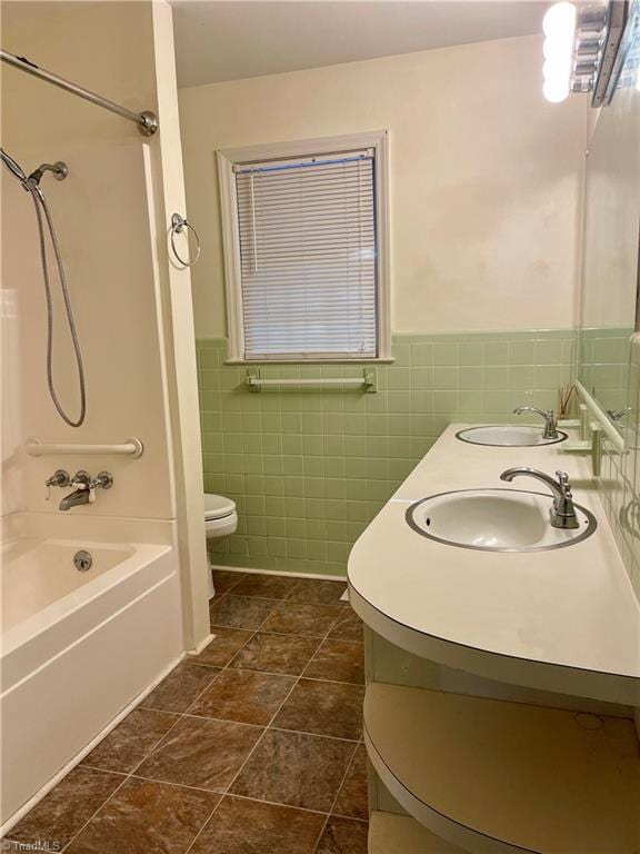 full bathroom with tile patterned flooring, toilet, shower / washtub combination, tile walls, and vanity