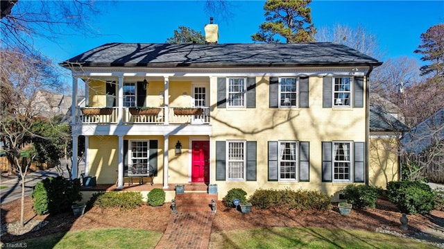 colonial house with a porch and a balcony