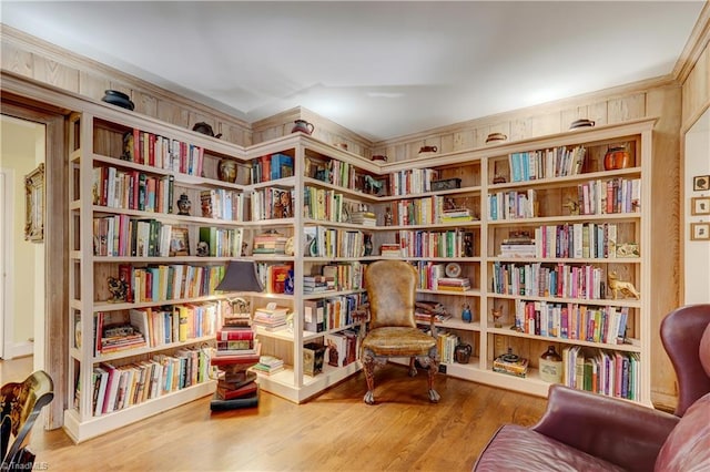 living area featuring hardwood / wood-style flooring and ornamental molding