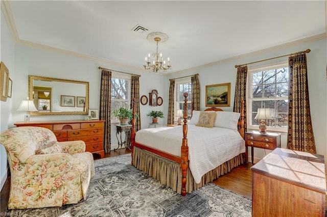 bedroom with ornamental molding, hardwood / wood-style flooring, and a notable chandelier