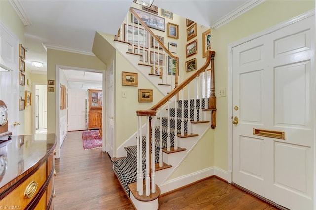 stairs featuring wood-type flooring and ornamental molding