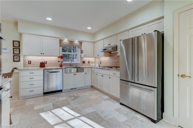 kitchen with light stone countertops, backsplash, stainless steel appliances, sink, and white cabinets