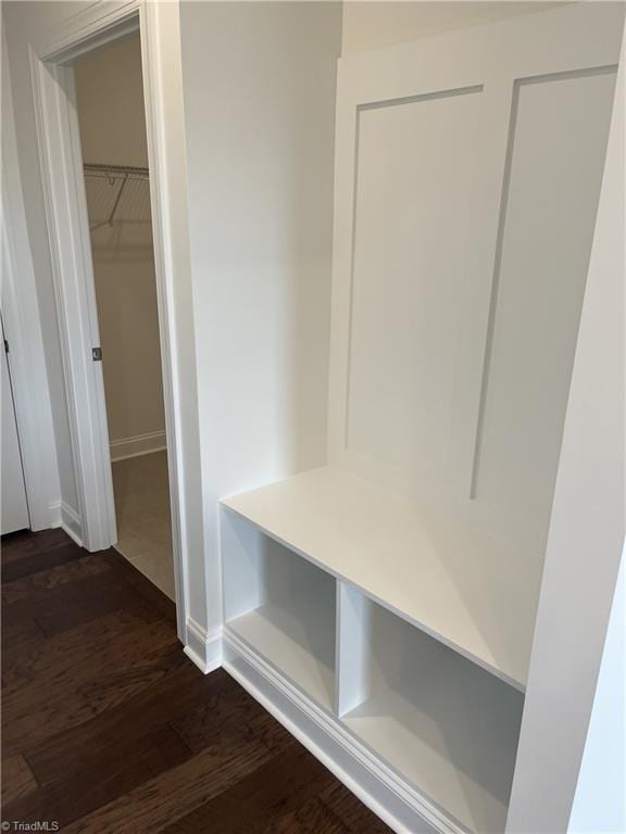 mudroom featuring baseboards and dark wood-type flooring