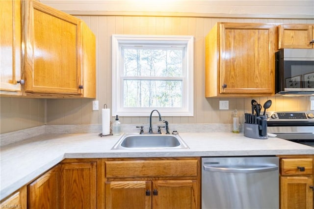 kitchen featuring a sink, stainless steel appliances, tasteful backsplash, and light countertops