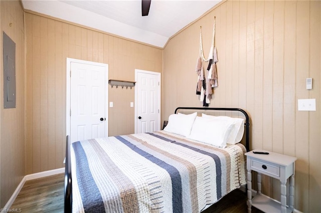 bedroom featuring ceiling fan, baseboards, lofted ceiling, electric panel, and wood finished floors