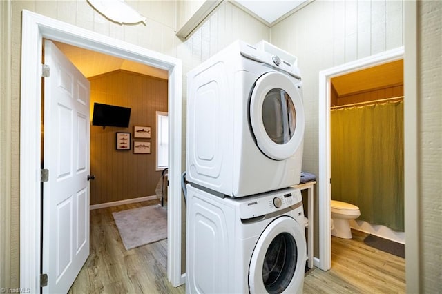 washroom with light wood-type flooring, laundry area, and stacked washing maching and dryer