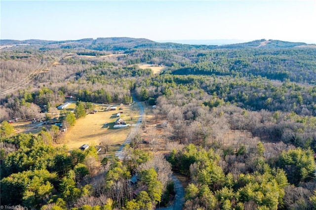 birds eye view of property featuring a mountain view and a wooded view