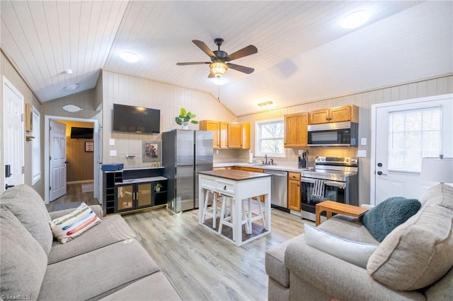 living area with lofted ceiling, wood ceiling, light wood finished floors, and ceiling fan