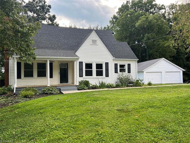 new england style home with a garage, roof with shingles, an outdoor structure, and a front yard