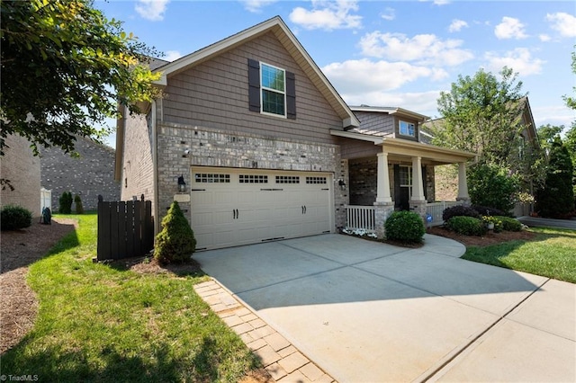 view of front of house featuring a garage, a front yard, and covered porch