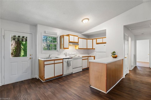 kitchen featuring a textured ceiling, white appliances, vaulted ceiling, sink, and dark hardwood / wood-style floors