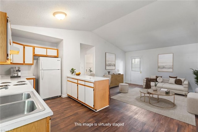 kitchen with sink, dark hardwood / wood-style flooring, kitchen peninsula, white fridge, and lofted ceiling