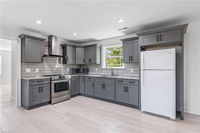 kitchen with sink, gray cabinets, wall chimney exhaust hood, and stainless steel appliances