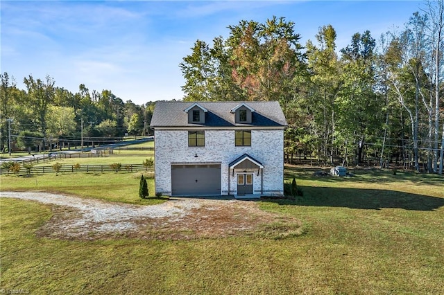 view of front of property with a garage, a front yard, and a rural view