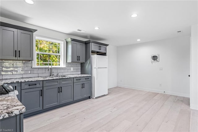 kitchen featuring sink, tasteful backsplash, gray cabinetry, and white fridge