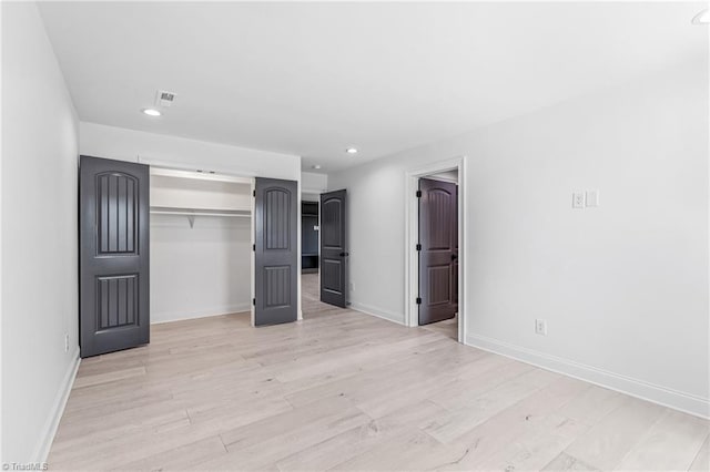 unfurnished bedroom featuring light hardwood / wood-style floors and a closet