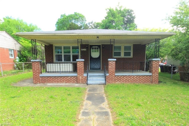 bungalow-style home featuring fence, a porch, brick siding, and a front yard