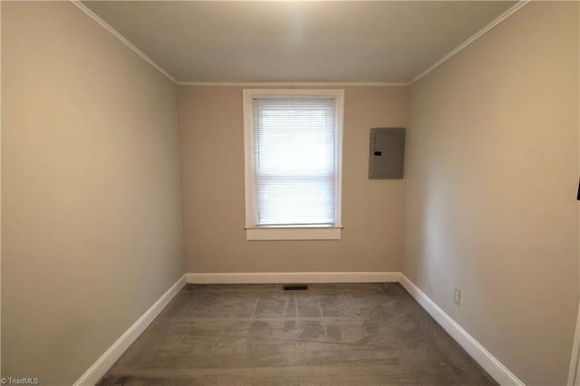spare room with baseboards, ornamental molding, and electric panel