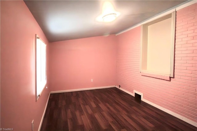 spare room with baseboards, a wealth of natural light, lofted ceiling, and dark wood-type flooring