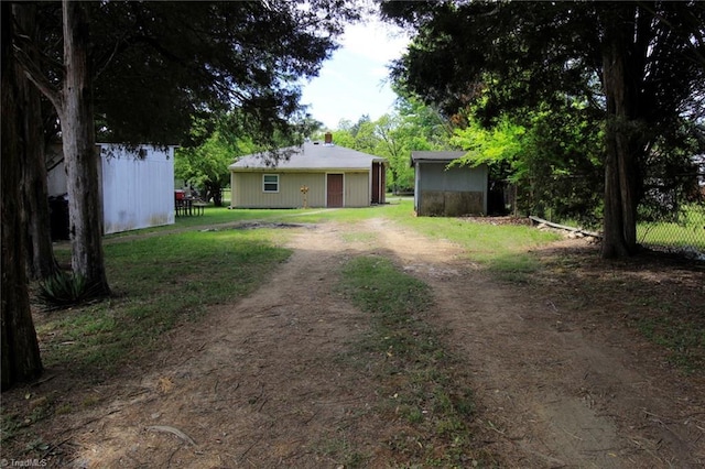 view of yard featuring driveway and an outdoor structure