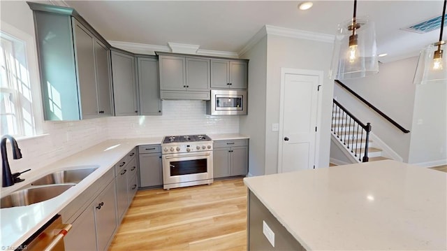 3043 Loch Dr, Winston-Salem, NC 27106 - kitchen featuring appliances with stainless steel finishes, gray cabinetry, a sink, backsplash, and ornamental molding