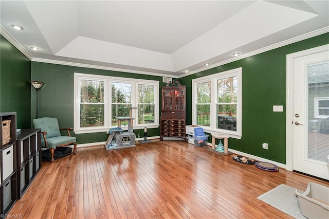 sitting room featuring a tray ceiling, baseboards, ornamental molding, and hardwood / wood-style flooring