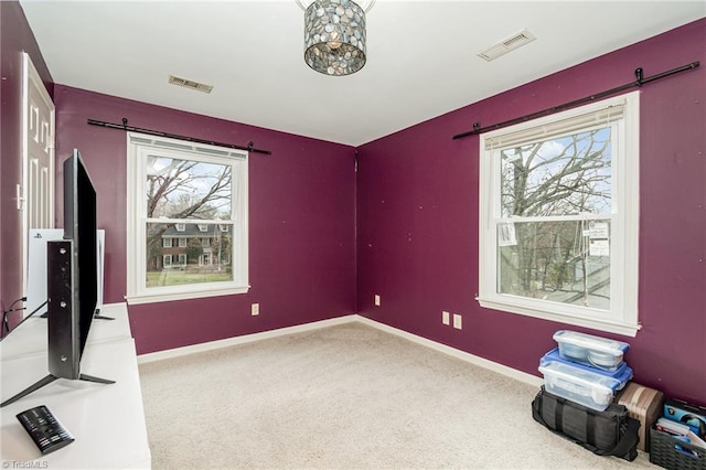 carpeted spare room featuring baseboards and visible vents