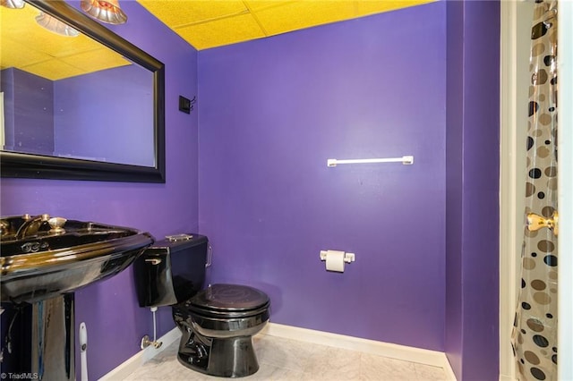 bathroom featuring tile patterned floors, a shower with curtain, baseboards, and toilet