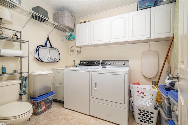 laundry area with a textured ceiling, washing machine and dryer, and laundry area