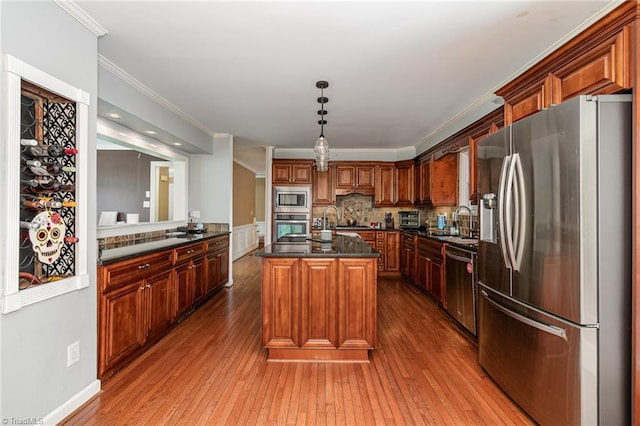 kitchen with dark countertops, dark wood-style floors, crown molding, and stainless steel appliances