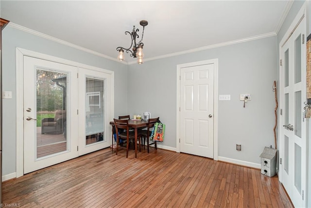 dining area featuring light wood finished floors, a chandelier, and ornamental molding