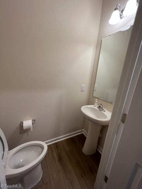 bathroom featuring wood-type flooring and toilet