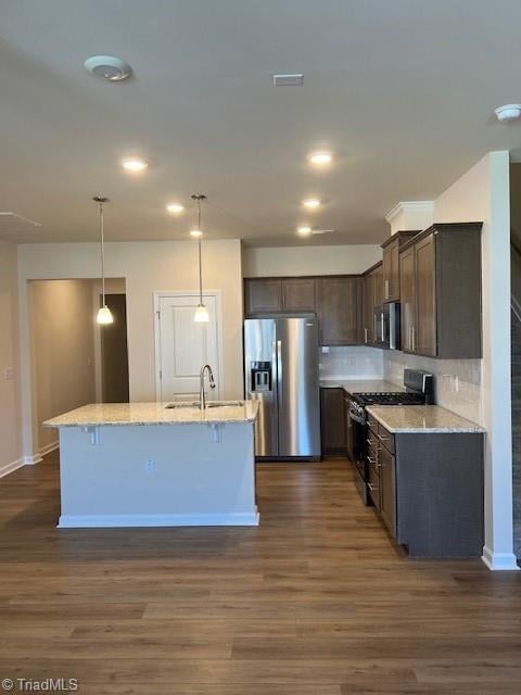 kitchen featuring dark wood-type flooring, appliances with stainless steel finishes, sink, and light stone counters