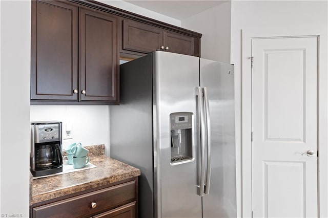 kitchen featuring dark brown cabinetry, stainless steel fridge, and light countertops