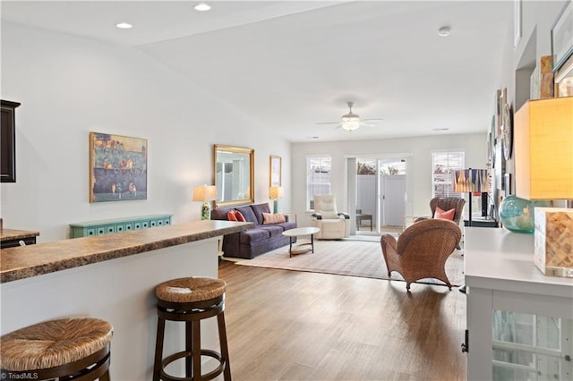 living room featuring vaulted ceiling, recessed lighting, a ceiling fan, and wood finished floors