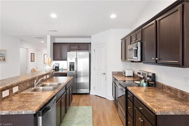 kitchen featuring visible vents, dark brown cabinets, stainless steel appliances, and a sink