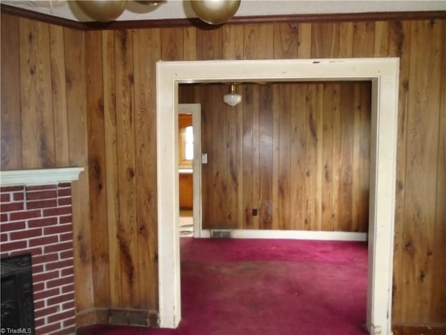 815 Camel Ave, Winston-Salem, NC 27101 - unfurnished living room with wooden walls, a brick fireplace, and carpet flooring