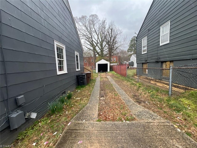exterior space with a garage, concrete driveway, and fence
