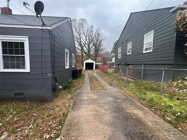 view of side of property with fence, driveway, and crawl space