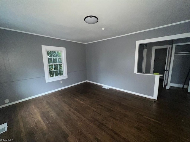 unfurnished room featuring wood finished floors, baseboards, and ornamental molding
