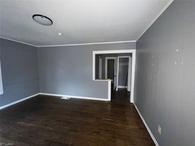 unfurnished room featuring wood finished floors, baseboards, and ornamental molding