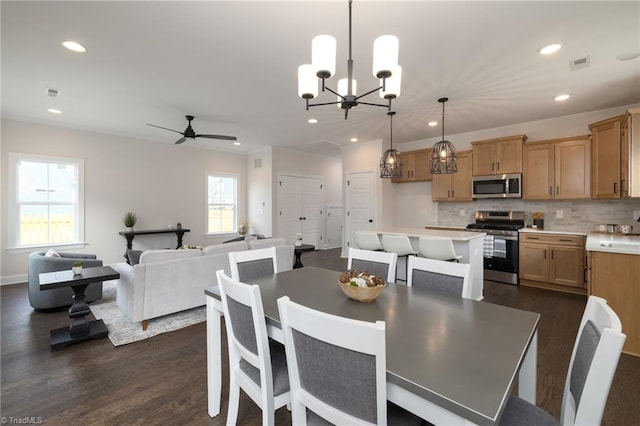 dining space featuring ceiling fan with notable chandelier, visible vents, dark wood-type flooring, and recessed lighting